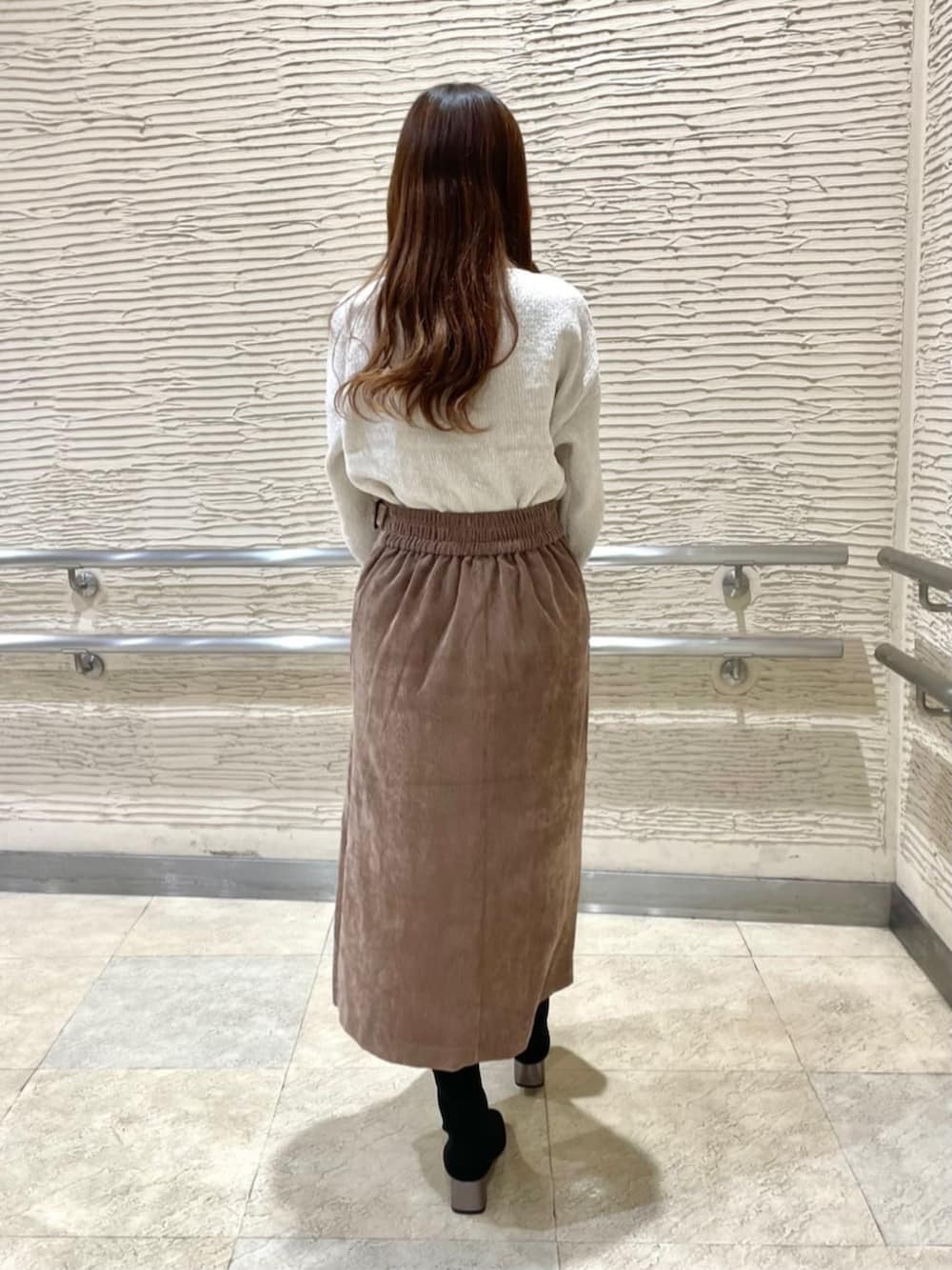 ブラック系のブーツ、ホワイト系のニット/セーター、ブラウン系のスカートを着用したレディースの冬コーディネートの3枚目の写真