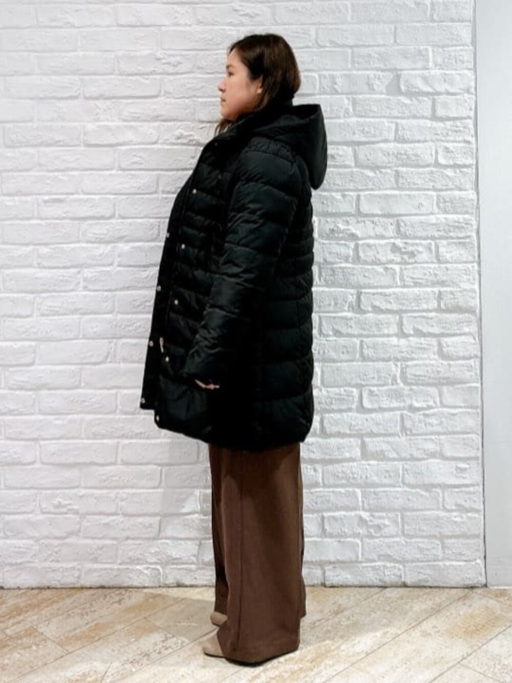 レッド系のニット/セーター、ブラック系のその他アウター、ブラウン系のその他パンツを着用したレディースの冬コーディネートの2枚目の写真