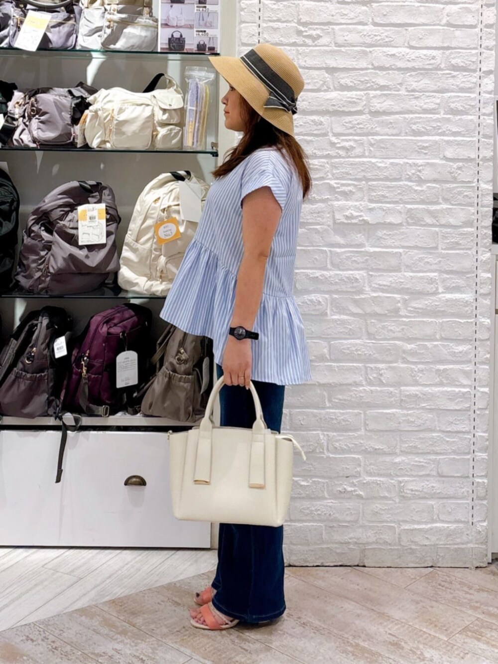ブルー系のシャツ/ブラウス、ホワイト系のトートバッグ、オレンジ系のサンダルを着用したレディースの夏コーディネートの2枚目の写真