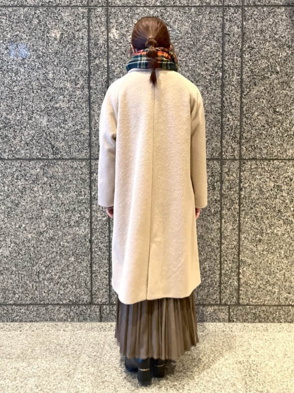 ブラック系のブーツ、ブラウン系のスカート、ベージュ系のステンカラーコートを着用したレディースの冬コーディネートの3枚目の写真