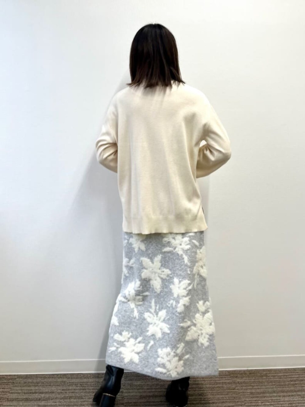 グレー系のスカート、ホワイト系のニット/セーターを着用したレディースの冬コーディネートの4枚目の写真