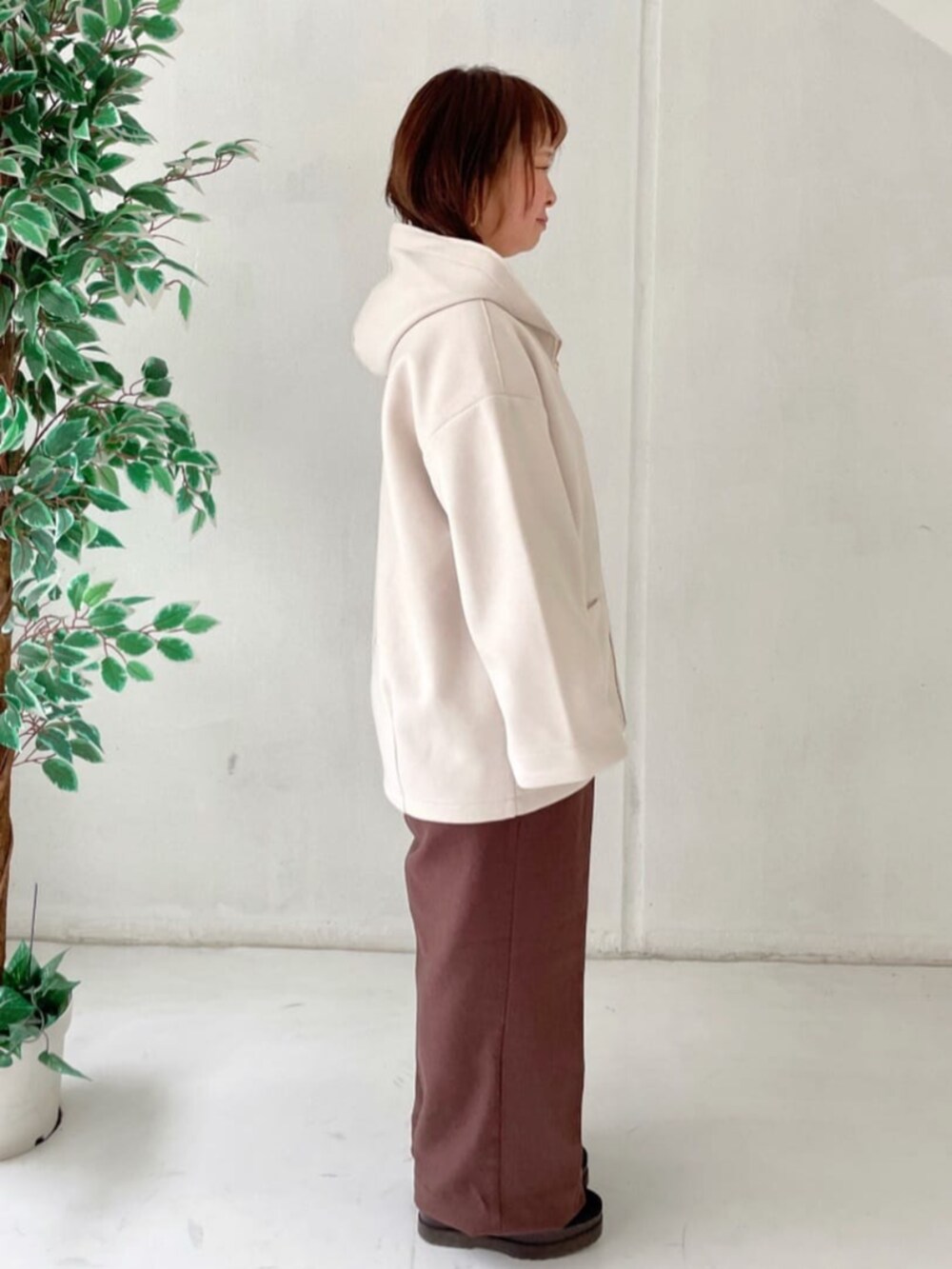 ホワイト系のその他アウター、ホワイト系のニット/セーター、ブラウン系のその他パンツを着用したレディースの冬コーディネートの3枚目の写真