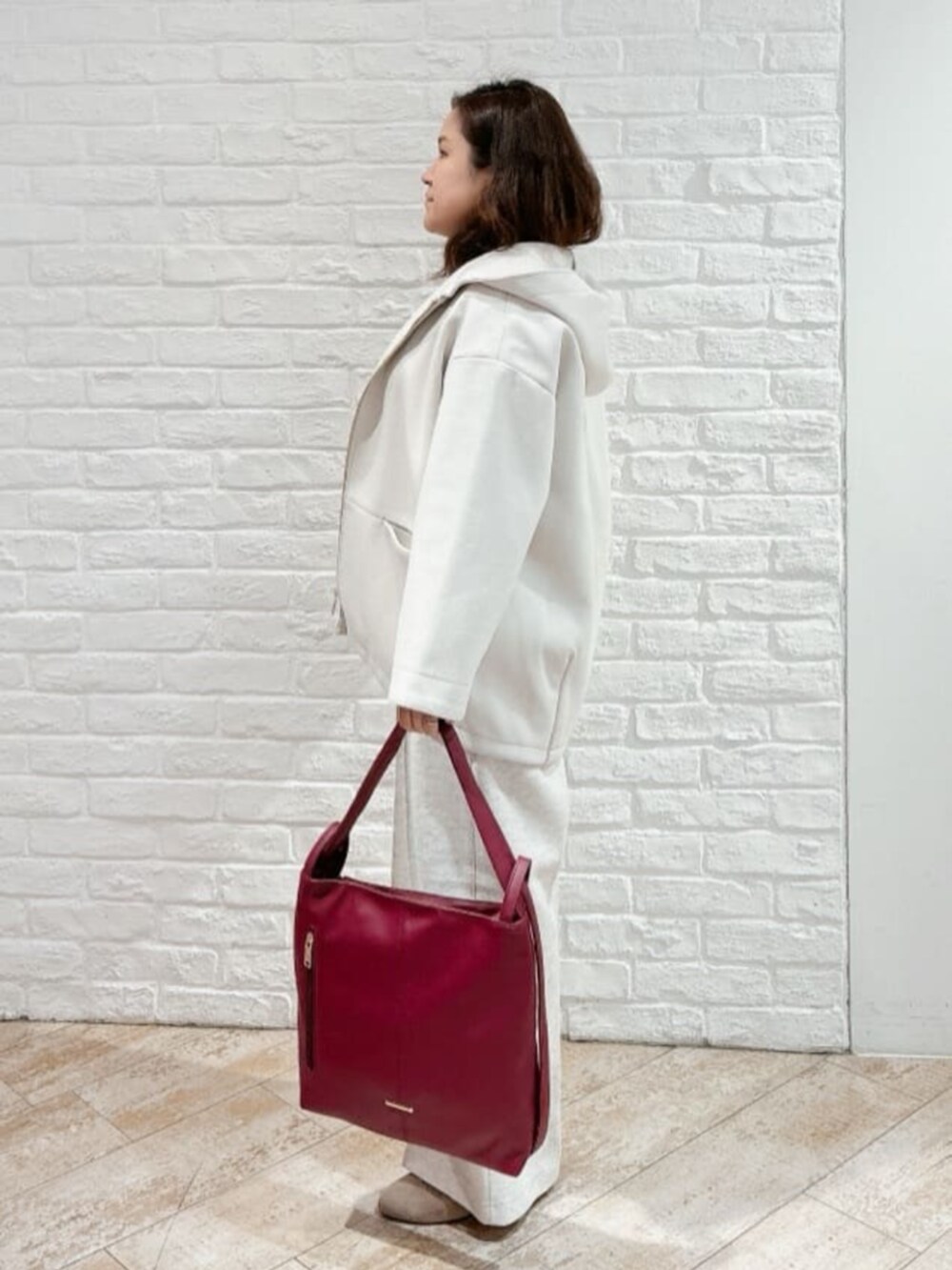 ホワイト系のその他アウター、ベージュ系のブーツ、ブラウン系のニット/セーターを着用したレディースの冬コーディネートの2枚目の写真