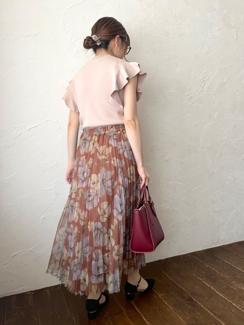 ピンク系のニット/セーター、ブラウン系のスカートを着用したレディースの秋コーディネートの3枚目の写真