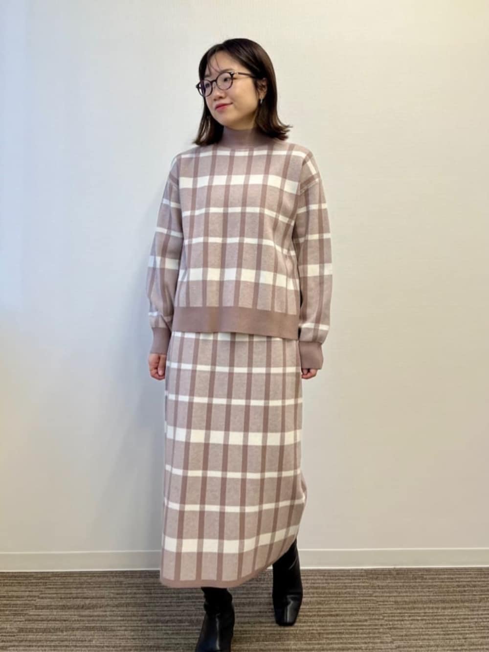 ベージュ系のセットアップを着用したレディースの冬コーディネートの2枚目の写真