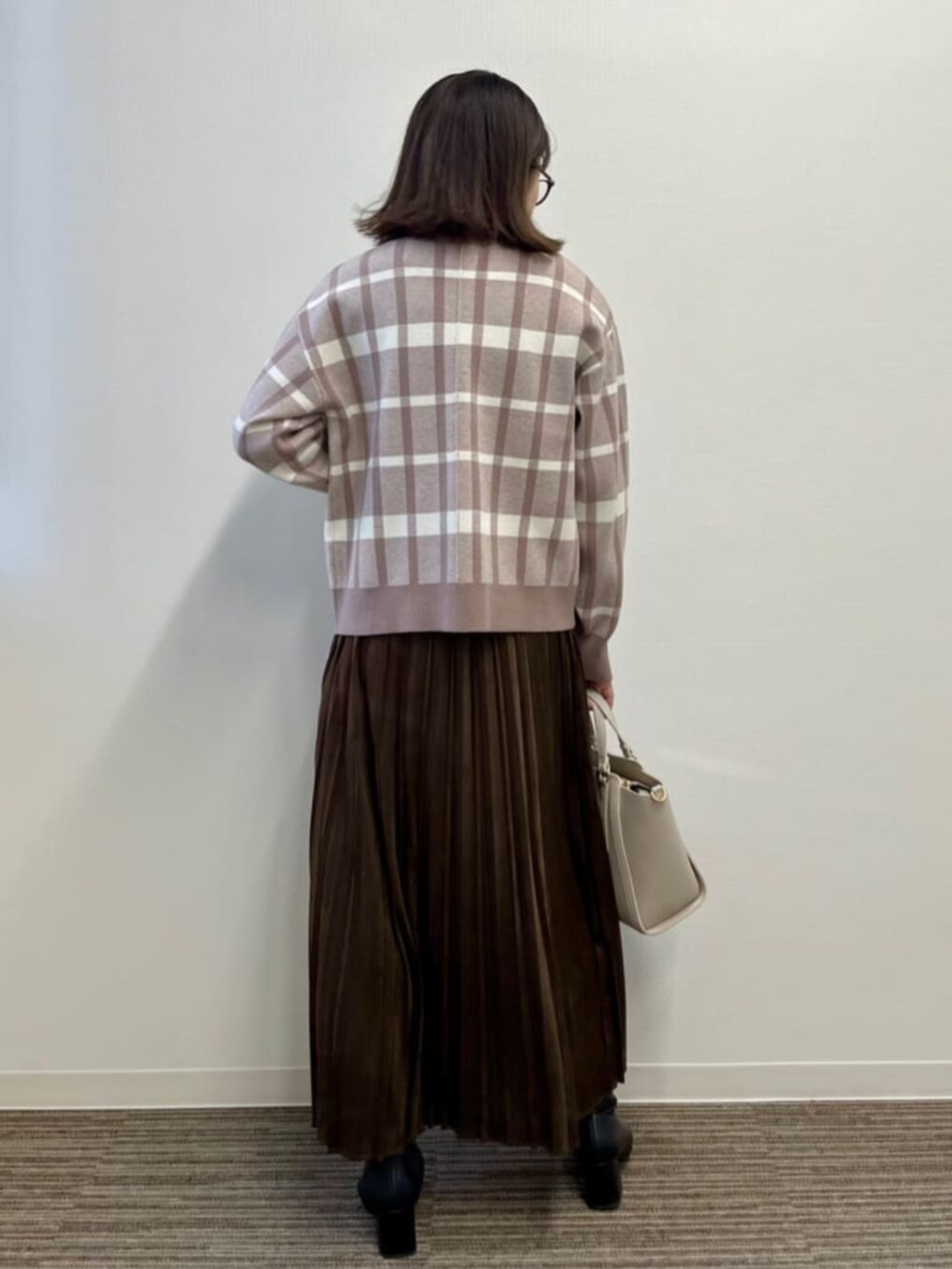 ベージュ系のセットアップ、ブラウン系のスカートを着用したレディースの冬コーディネートの4枚目の写真
