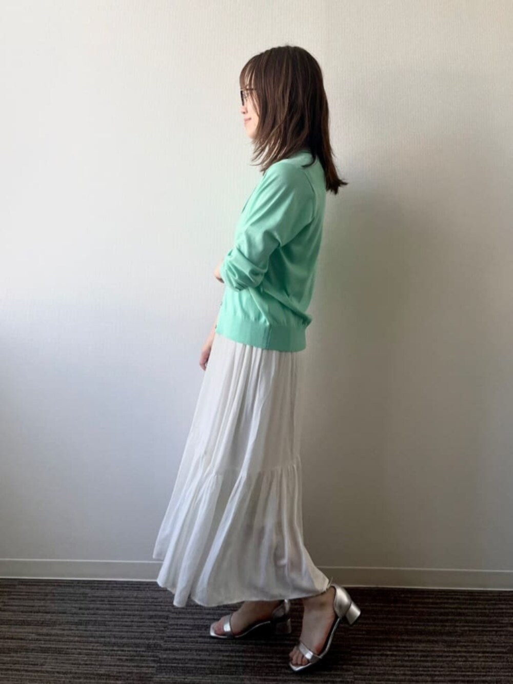 グリーン系のカーディガン/ボレロ、ホワイト系のスカートを着用したレディースの夏コーディネートの2枚目の写真