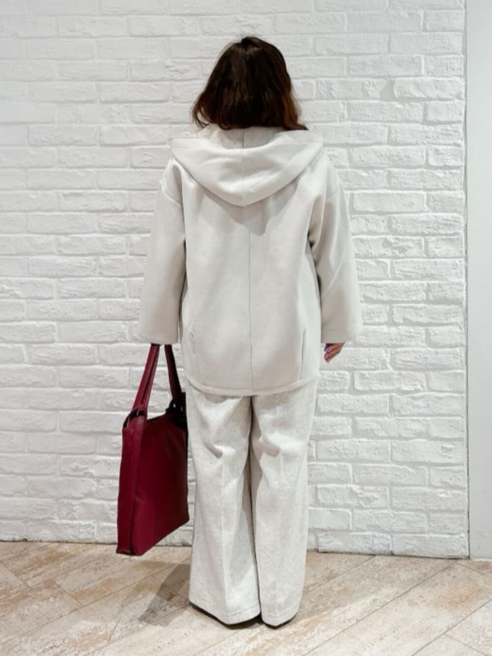 ホワイト系のその他アウター、ベージュ系のブーツ、ブラウン系のニット/セーターを着用したレディースの冬コーディネートの3枚目の写真