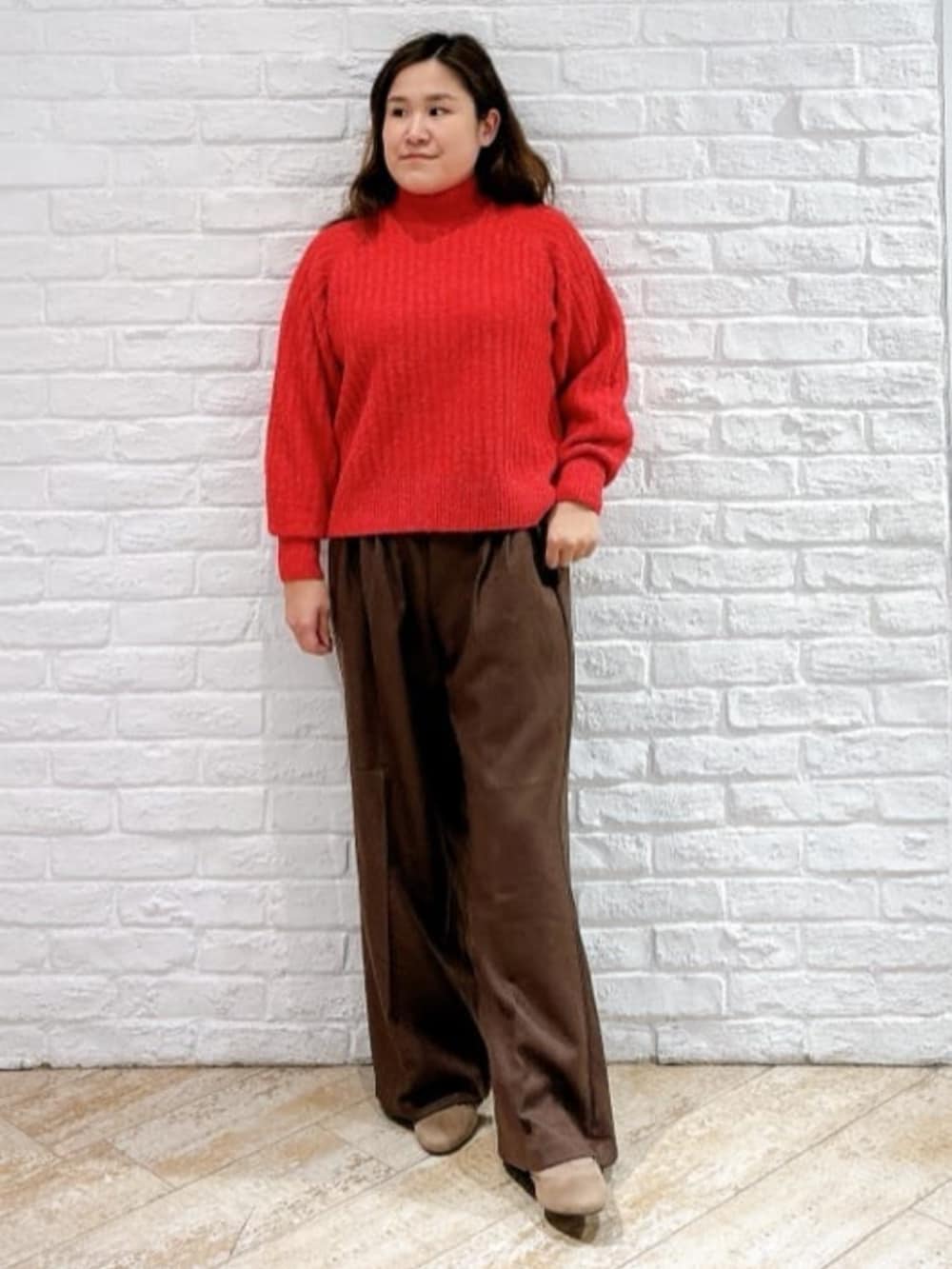 レッド系のニット/セーター、ブラック系のその他アウター、ブラウン系のその他パンツを着用したレディースの冬コーディネートの4枚目の写真