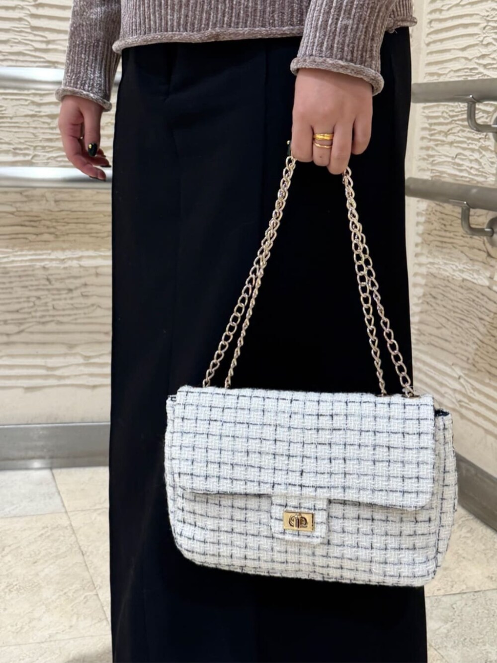 ブラック系のブーツ、ホワイト系のショルダーバッグ、ブラウン系のニット/セーターを着用したレディースの冬コーディネートの4枚目の写真