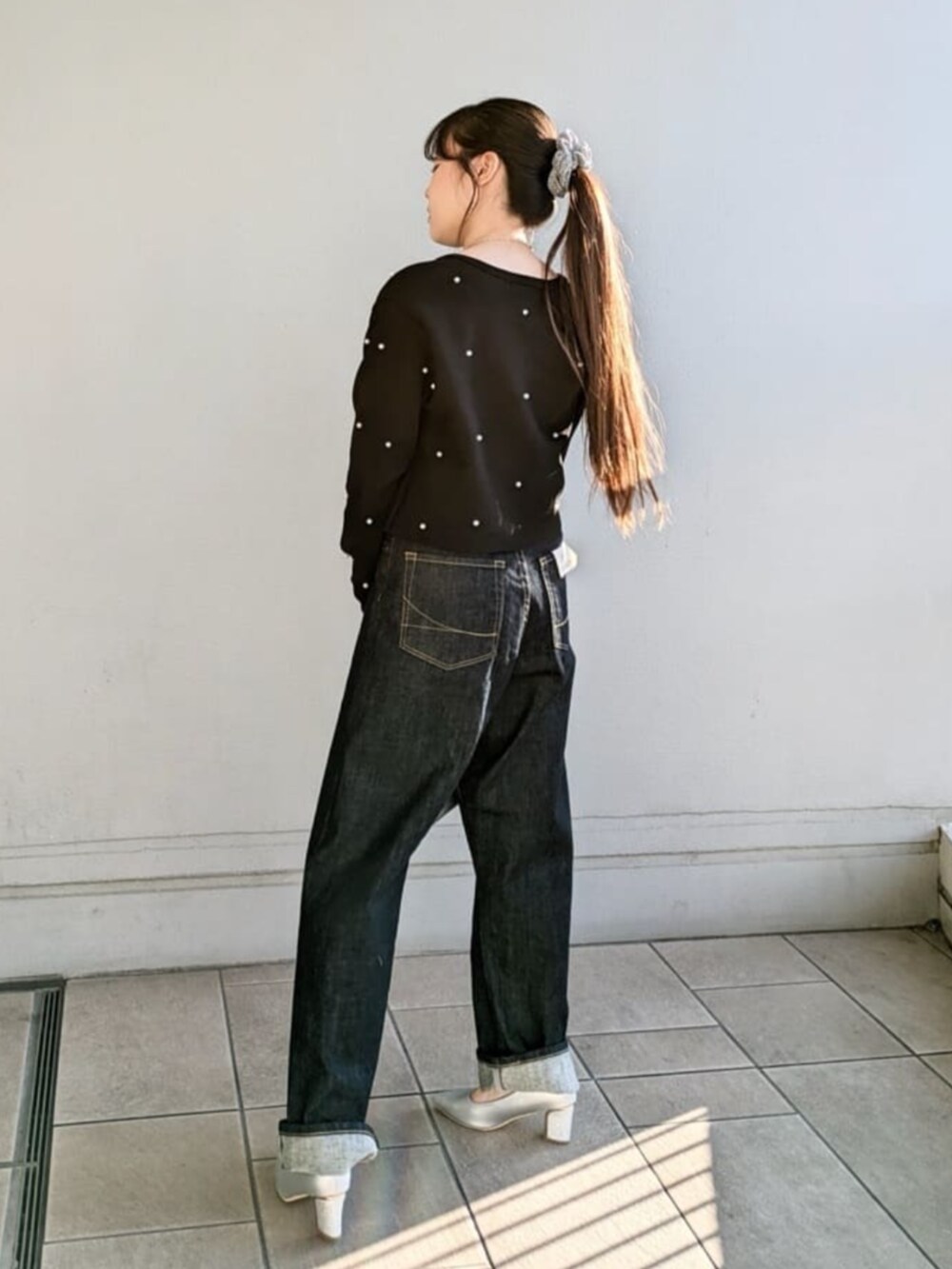 シルバー系のパンプス、シルバー系のハンドバッグ、ブラック系のカーディガン/ボレロを着用したレディースの冬コーディネートの3枚目の写真