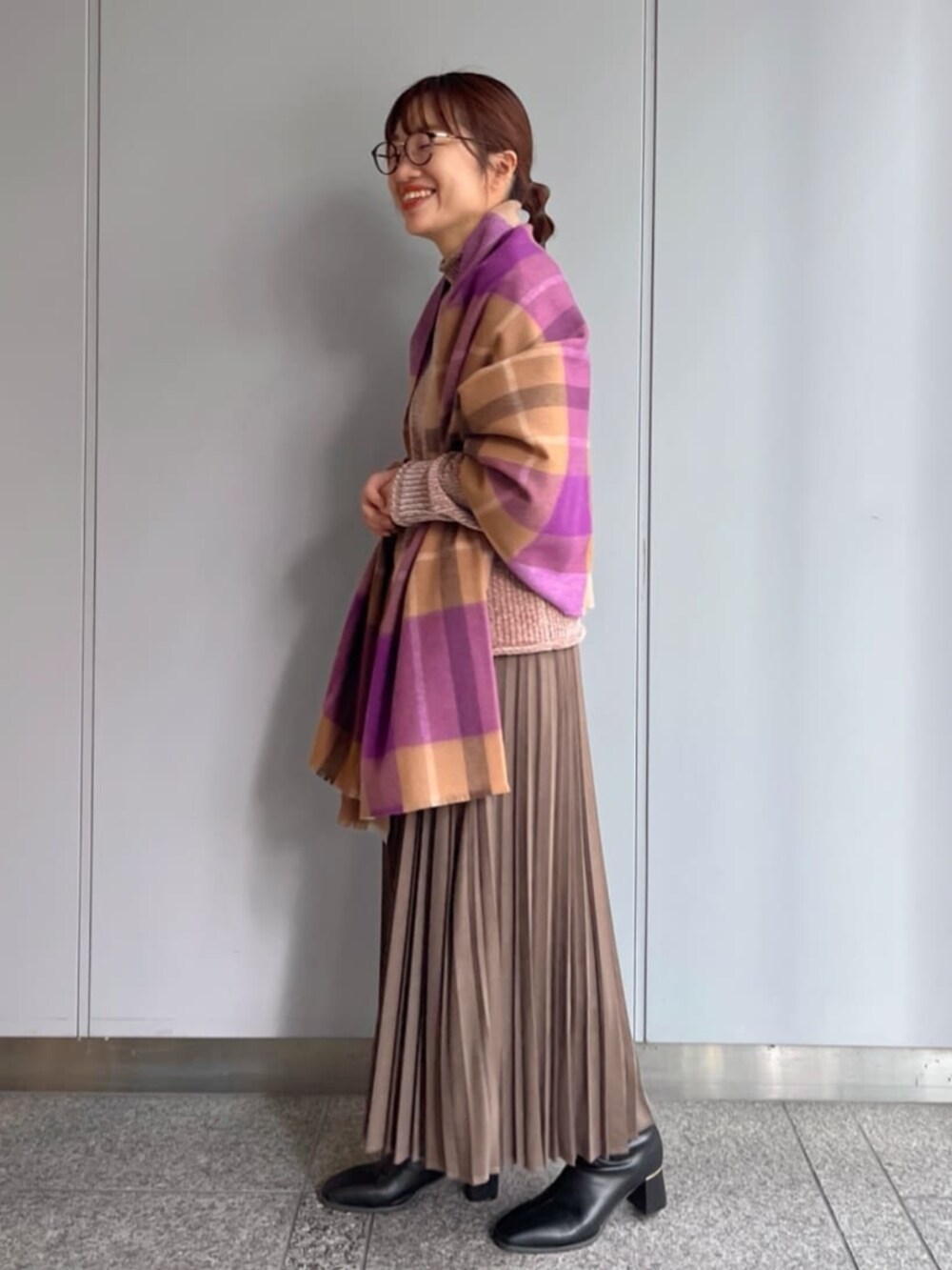 ブラウン系のスカート、ブラウン系のニット/セーター、パープル系のストール/ショールを着用したレディースの冬コーディネートの2枚目の写真