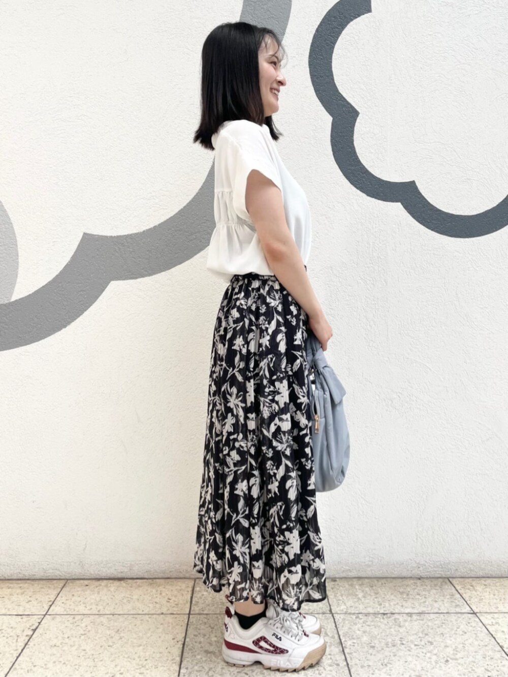 ホワイト系のシャツ/ブラウス、ブラック系のスカート、ブルー系のトートバッグを着用したレディースの夏コーディネートの2枚目の写真