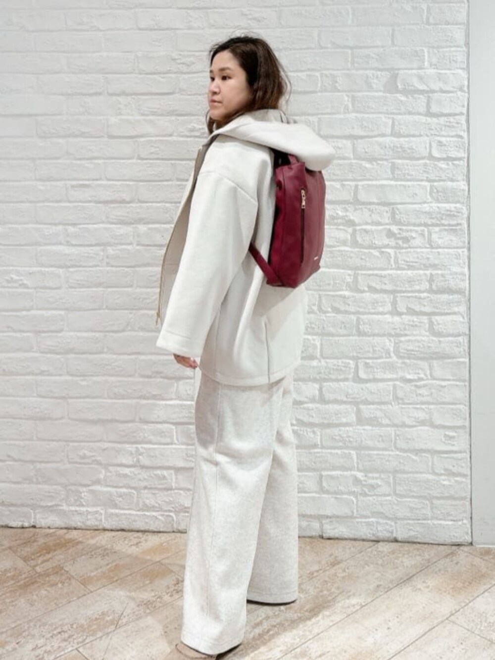 ホワイト系のその他アウター、ベージュ系のブーツ、ブラウン系のニット/セーターを着用したレディースの冬コーディネートの8枚目の写真