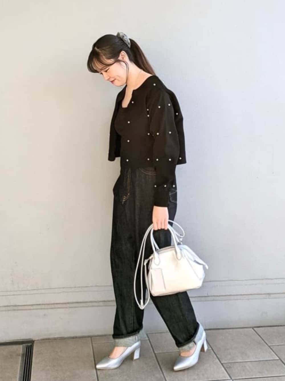 シルバー系のパンプス、シルバー系のハンドバッグ、ブラック系のカーディガン/ボレロを着用したレディースの冬コーディネートの2枚目の写真