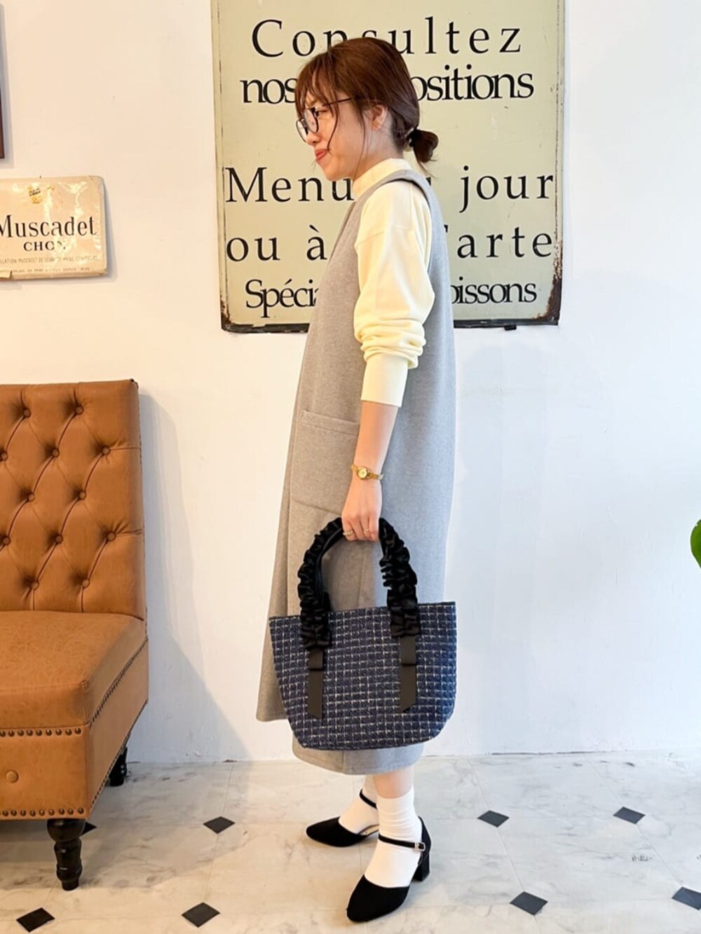 グレー系のスカート、ブルー系のハンドバッグを着用したレディースの秋コーディネートの2枚目の写真