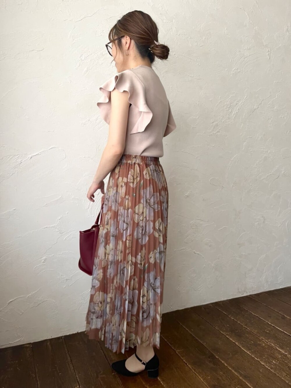 ピンク系のニット/セーター、ブラウン系のスカートを着用したレディースの秋コーディネートの2枚目の写真