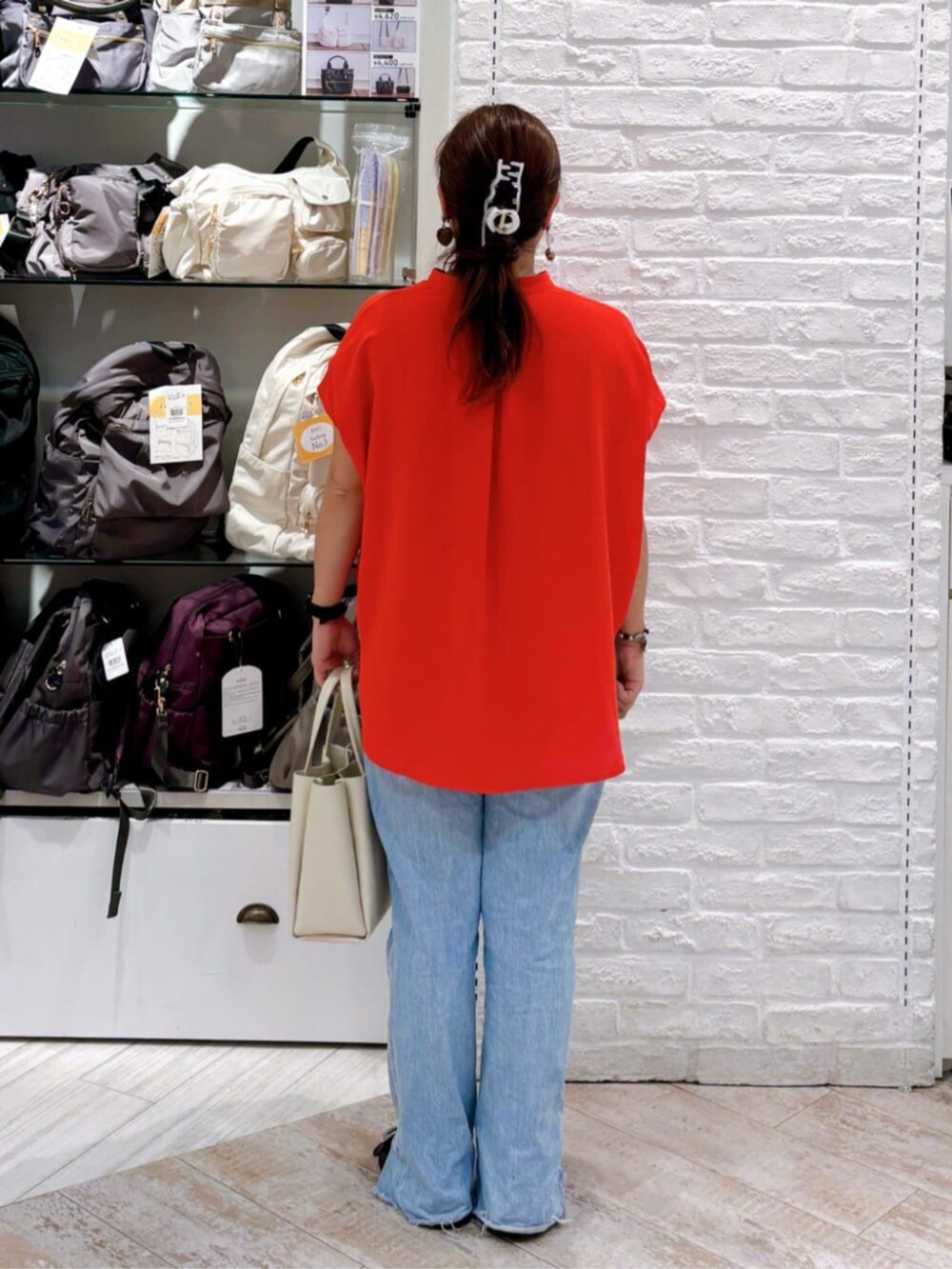 レッド系のシャツ/ブラウス、ホワイト系のハンドバッグ、シルバー系のネックレスを着用したレディースの夏コーディネートの3枚目の写真