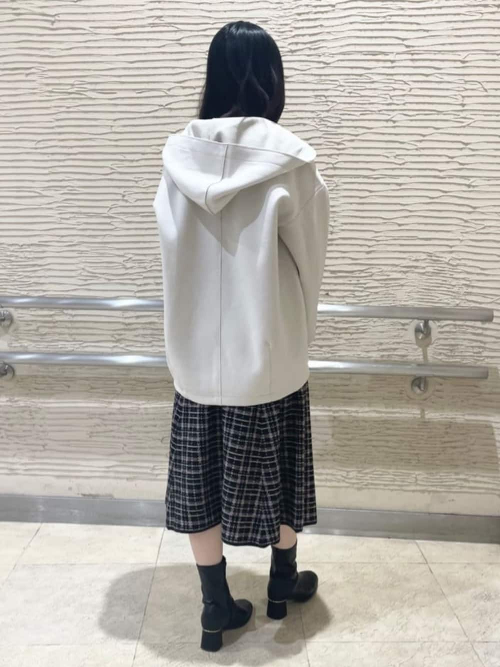 ブラック系のブーツ、ホワイト系のその他アウター、ベージュ系のワンピースを着用したレディースの冬コーディネートの3枚目の写真