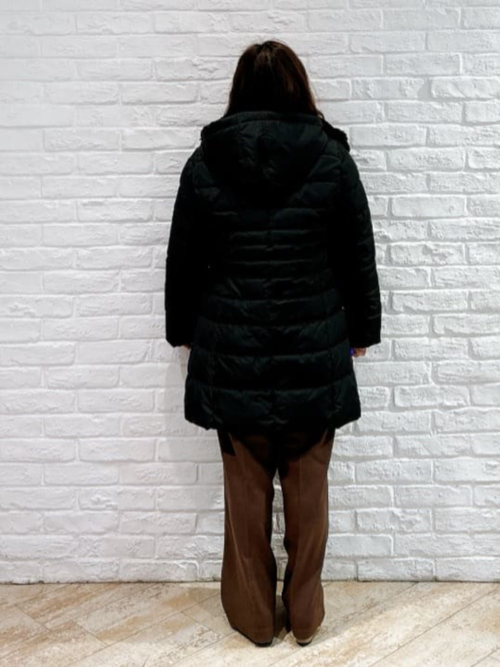 レッド系のニット/セーター、ブラック系のその他アウター、ブラウン系のその他パンツを着用したレディースの冬コーディネートの3枚目の写真