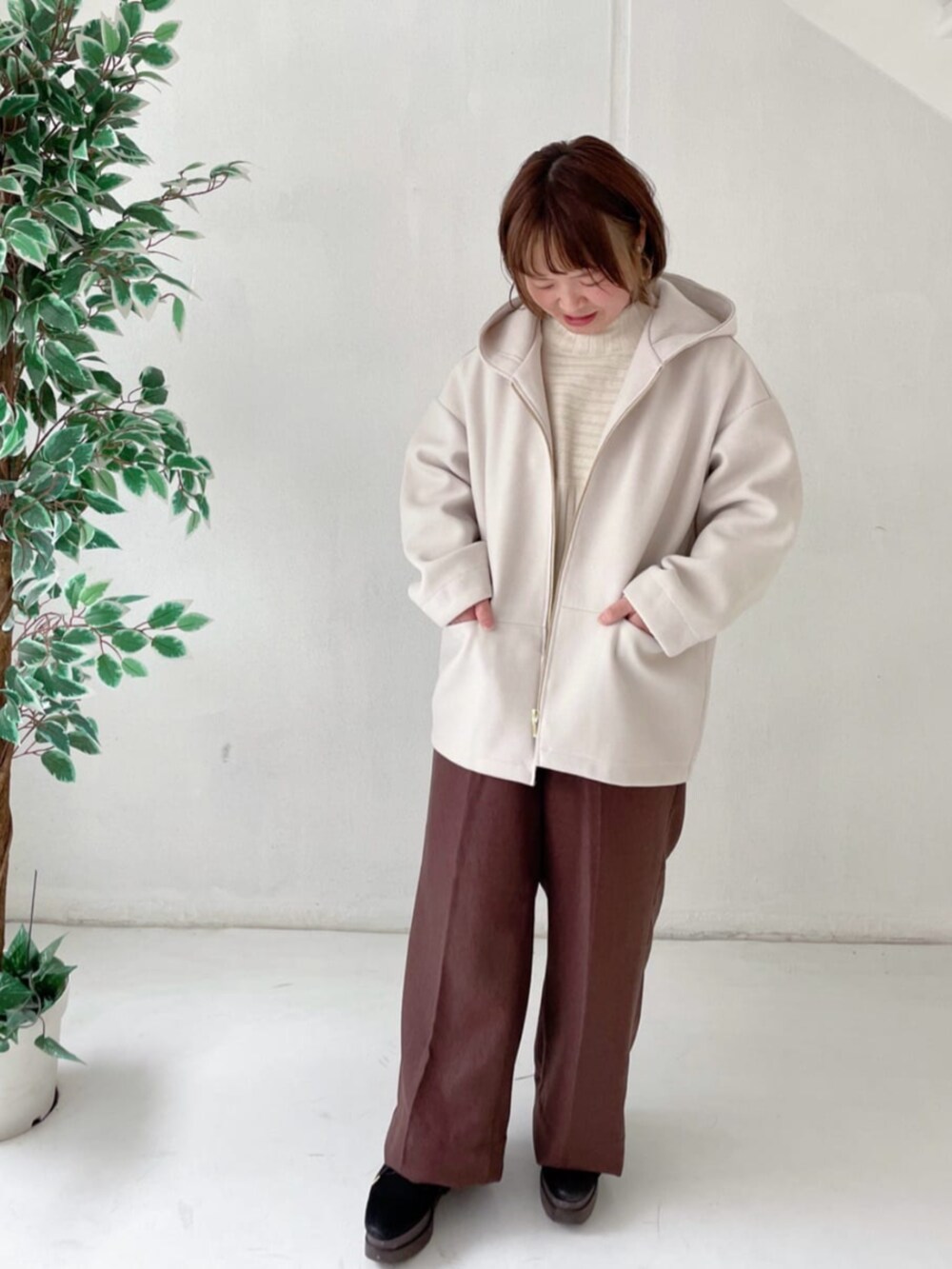 ホワイト系のその他アウター、ホワイト系のニット/セーター、ブラウン系のその他パンツを着用したレディースの冬コーディネートの5枚目の写真