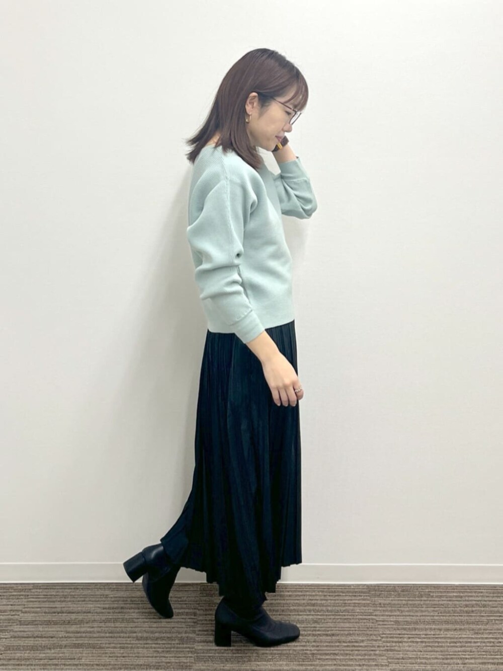 グリーン系のニット/セーターを着用したレディースの冬コーディネートの2枚目の写真