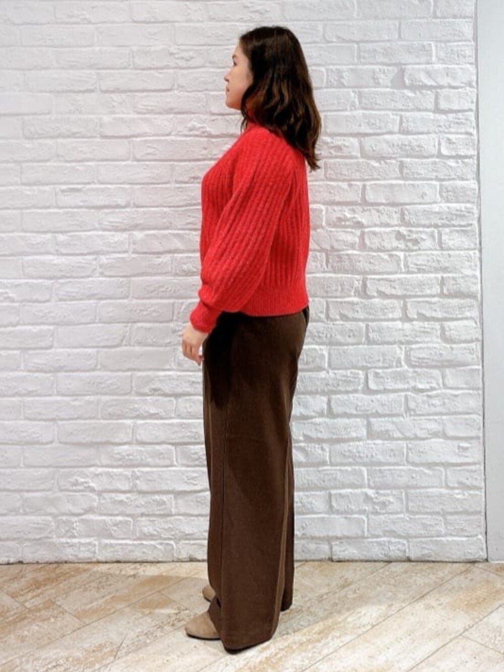 レッド系のニット/セーター、ブラック系のその他アウター、ブラウン系のその他パンツを着用したレディースの冬コーディネートの5枚目の写真