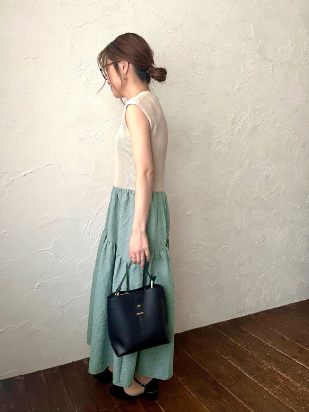 ブラック系のショルダーバッグ、グリーン系のワンピースを着用したレディースの夏コーディネートの2枚目の写真