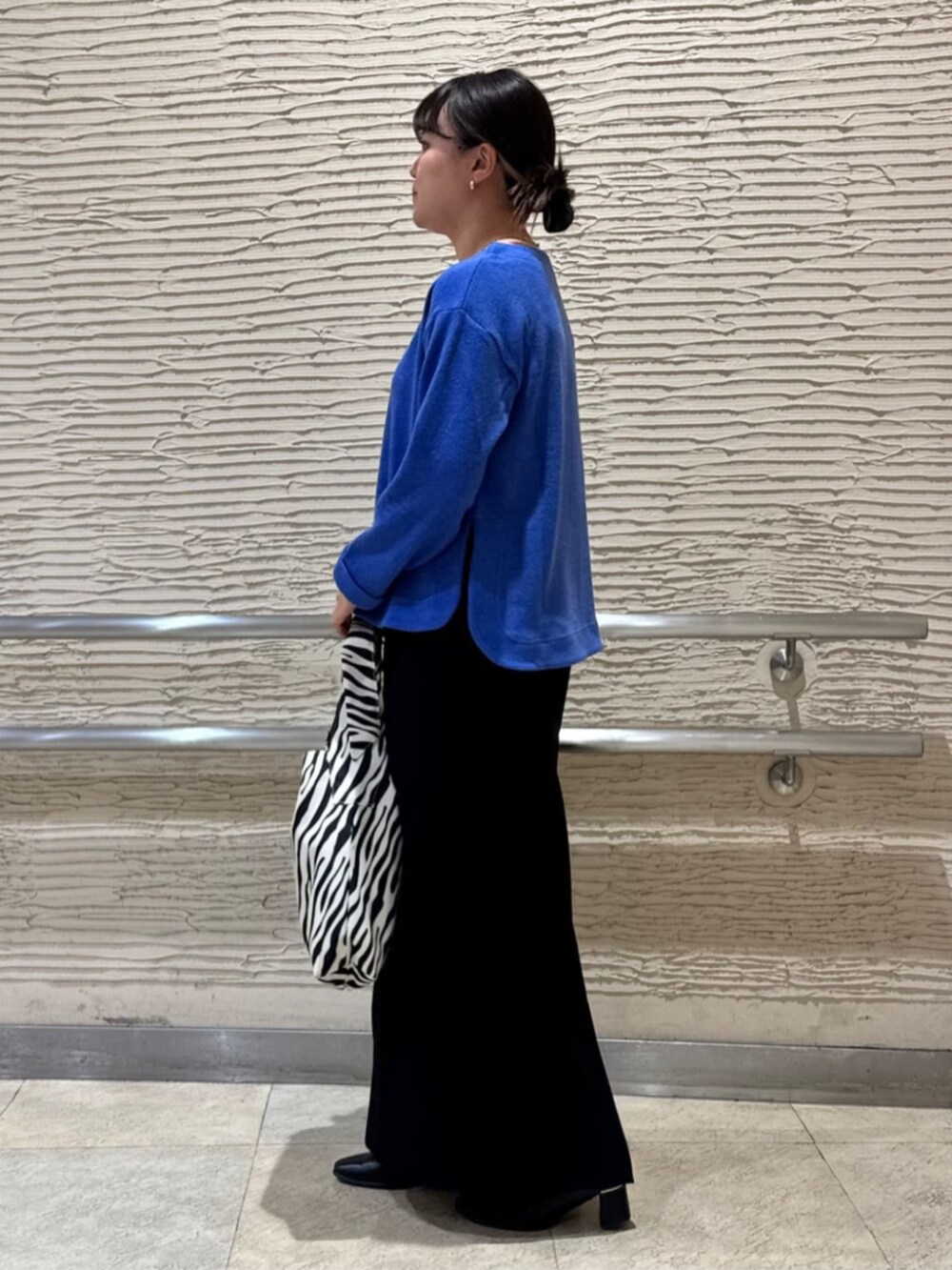 ブラック系のブーツ、ブルー系のTシャツ/カットソー、ブラック系のトートバッグを着用したレディースの冬コーディネートの2枚目の写真