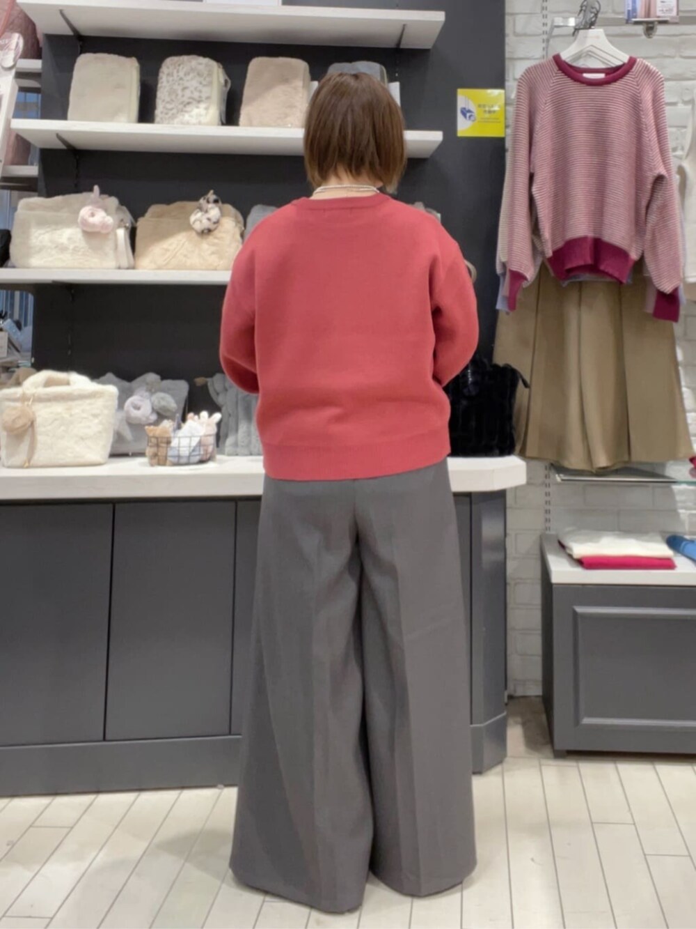 ピンク系のニット/セーター、グレー系のその他パンツを着用したレディースの秋コーディネートの3枚目の写真