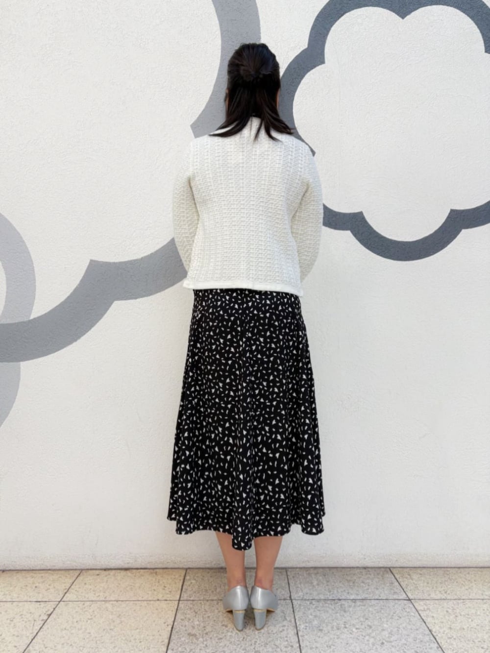 シルバー系のパンプス、シルバー系のハンドバッグ、ブラック系のスカートを着用したレディースの冬コーディネートの3枚目の写真