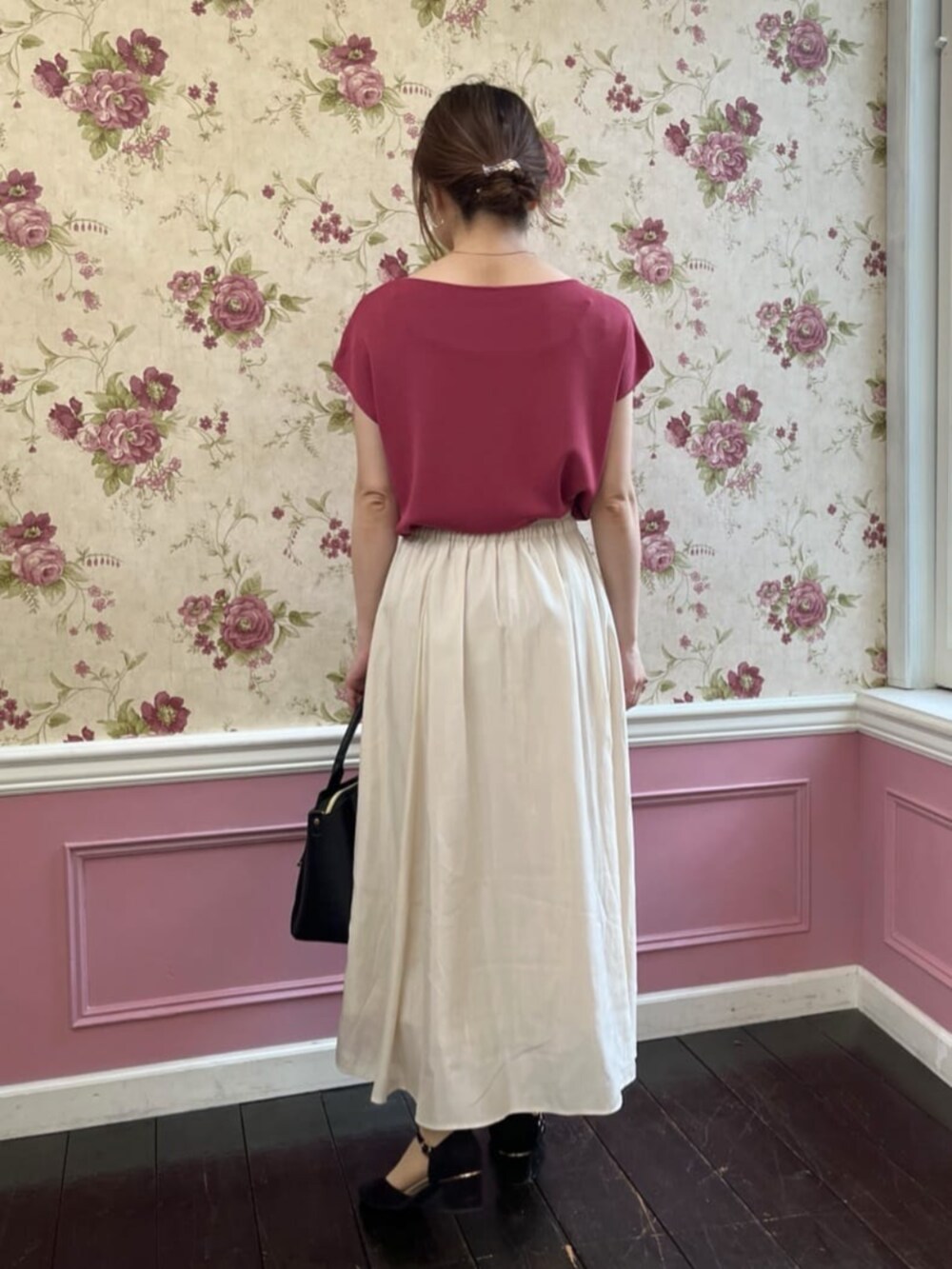 ピンク系のニット/セーター、ブラック系のハンドバッグを着用したレディースの秋コーディネートの3枚目の写真