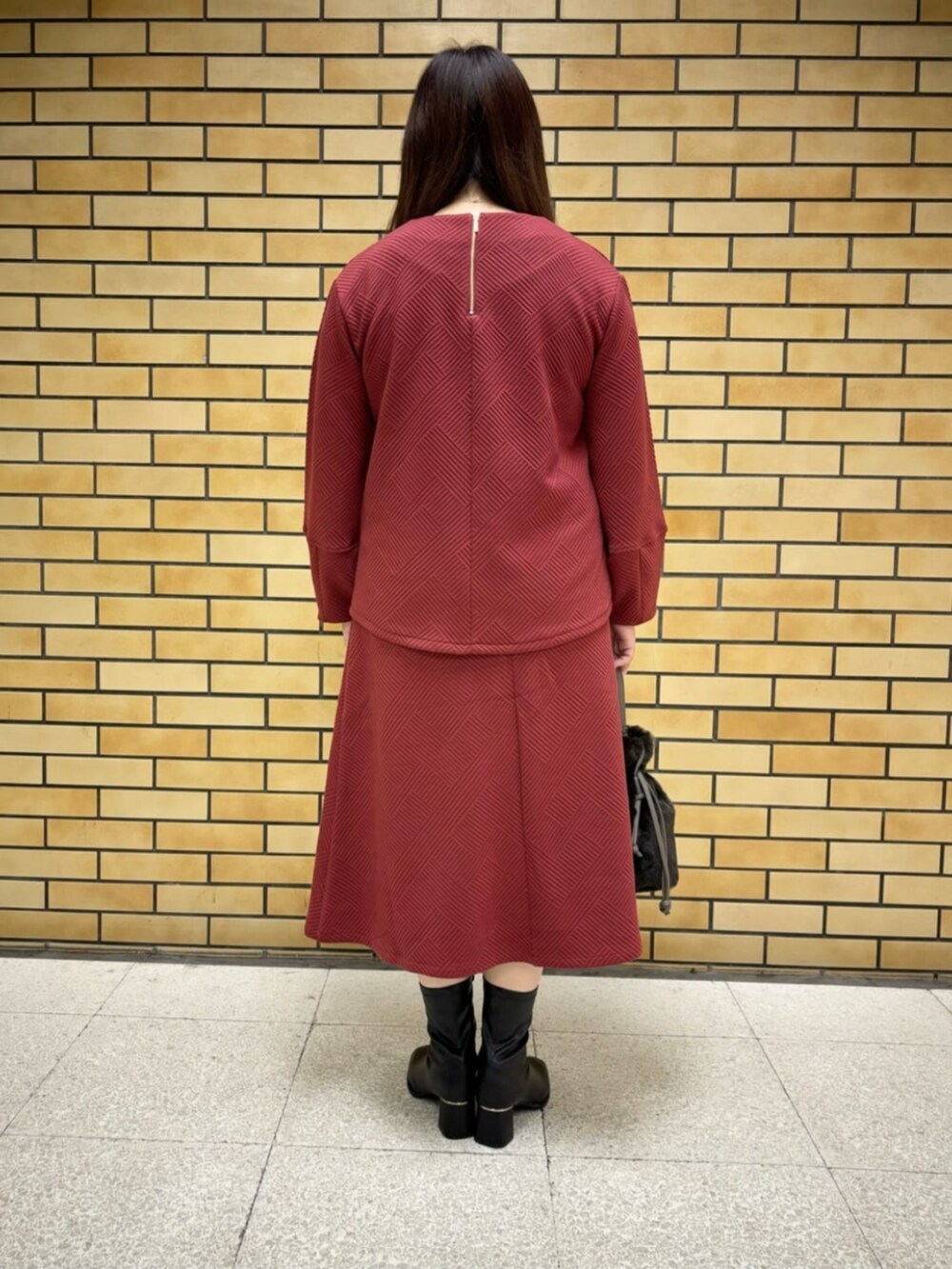 ブラック系のブーツ、グレー系のショルダーバッグ、レッド系のTシャツ/カットソーを着用したレディースの冬コーディネートの3枚目の写真