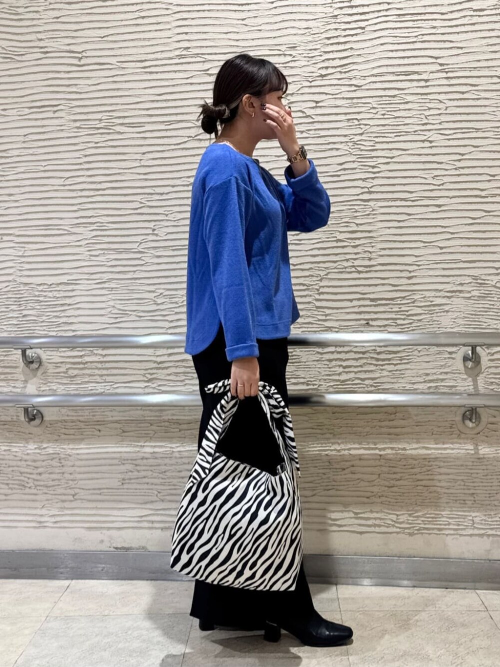 ブラック系のブーツ、ブルー系のTシャツ/カットソー、ブラック系のトートバッグを着用したレディースの冬コーディネートの4枚目の写真