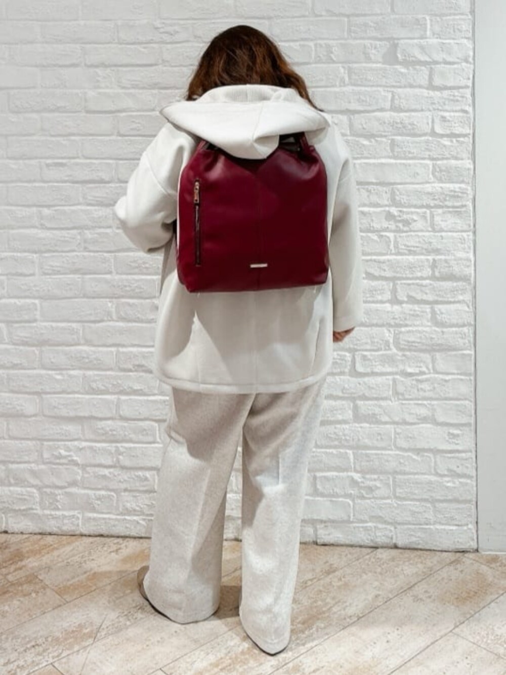 ホワイト系のその他アウター、ベージュ系のブーツ、ブラウン系のニット/セーターを着用したレディースの冬コーディネートの7枚目の写真