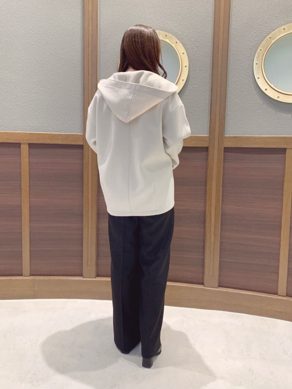 ブラック系のブーツ、ホワイト系のその他アウター、ブルー系のニット/セーターを着用したレディースの冬コーディネートの3枚目の写真