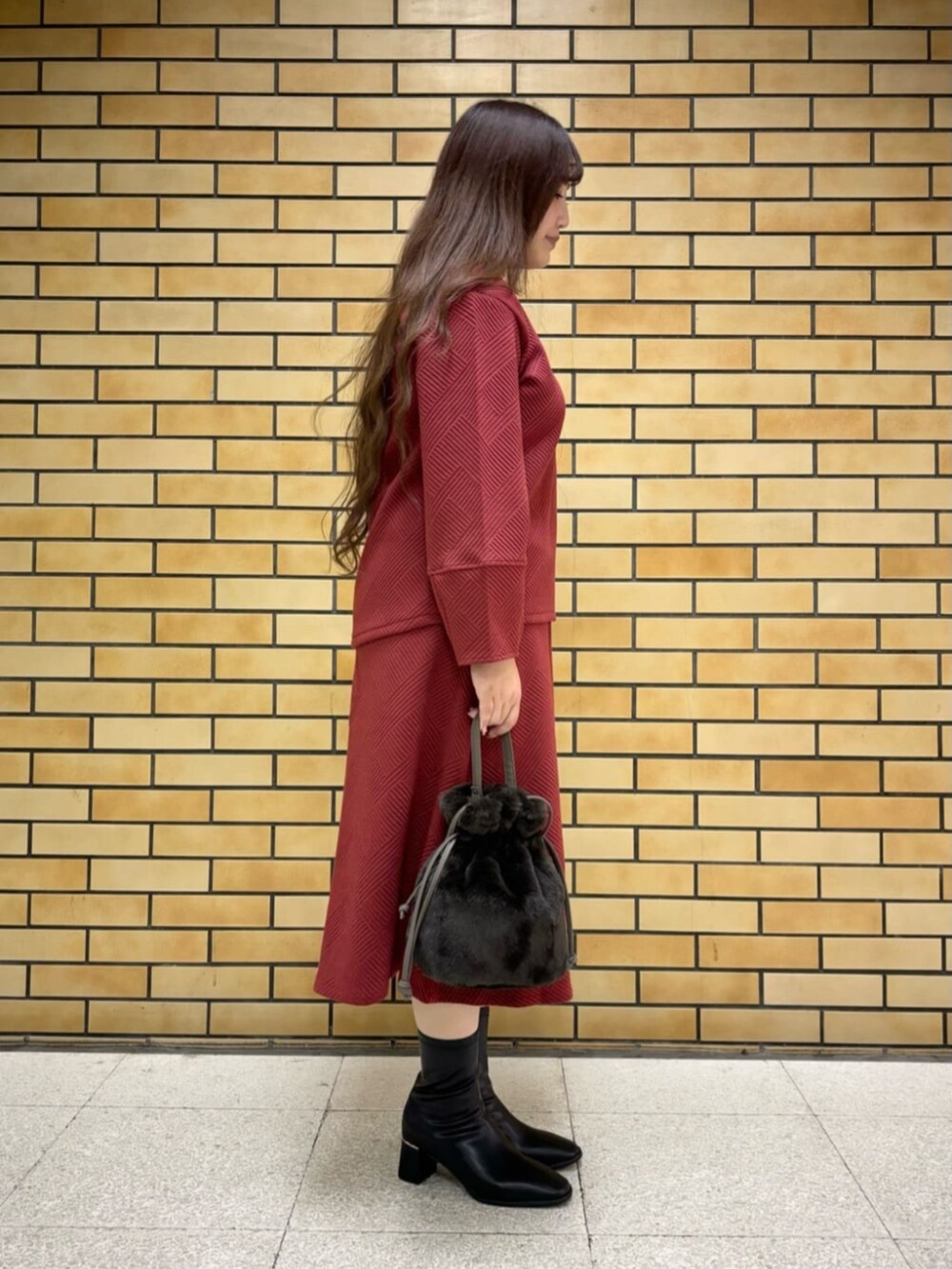 ブラック系のブーツ、グレー系のショルダーバッグ、レッド系のTシャツ/カットソーを着用したレディースの冬コーディネートの2枚目の写真