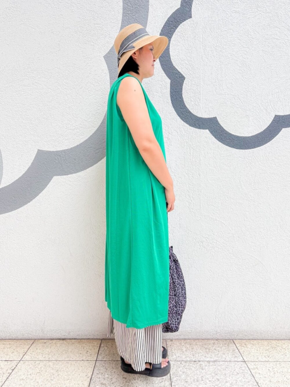 グレー系のトートバッグ、グリーン系のワンピース、ベージュ系のハットを着用したレディースの夏コーディネートの2枚目の写真