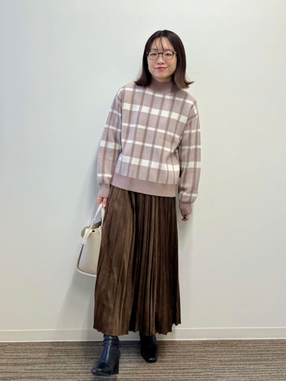 ベージュ系のセットアップ、ブラウン系のスカートを着用したレディースの冬コーディネートの2枚目の写真