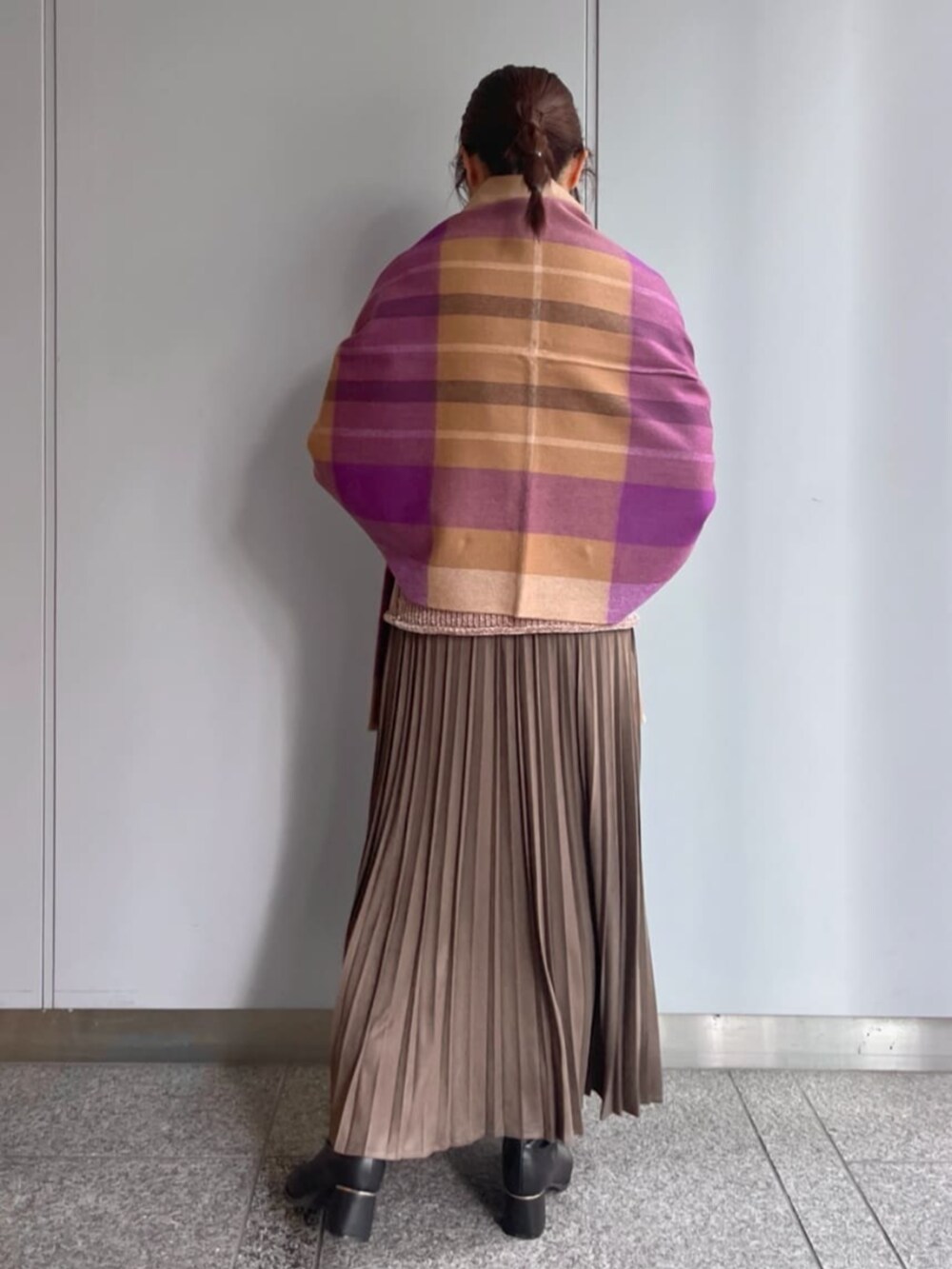 ブラウン系のスカート、ブラウン系のニット/セーター、パープル系のストール/ショールを着用したレディースの冬コーディネートの3枚目の写真