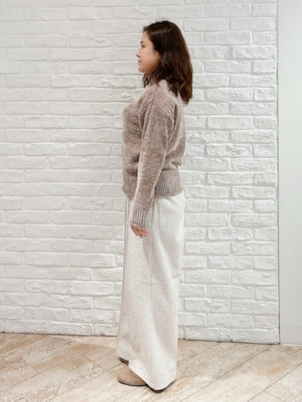 ホワイト系のその他アウター、ベージュ系のブーツ、ブラウン系のニット/セーターを着用したレディースの冬コーディネートの5枚目の写真