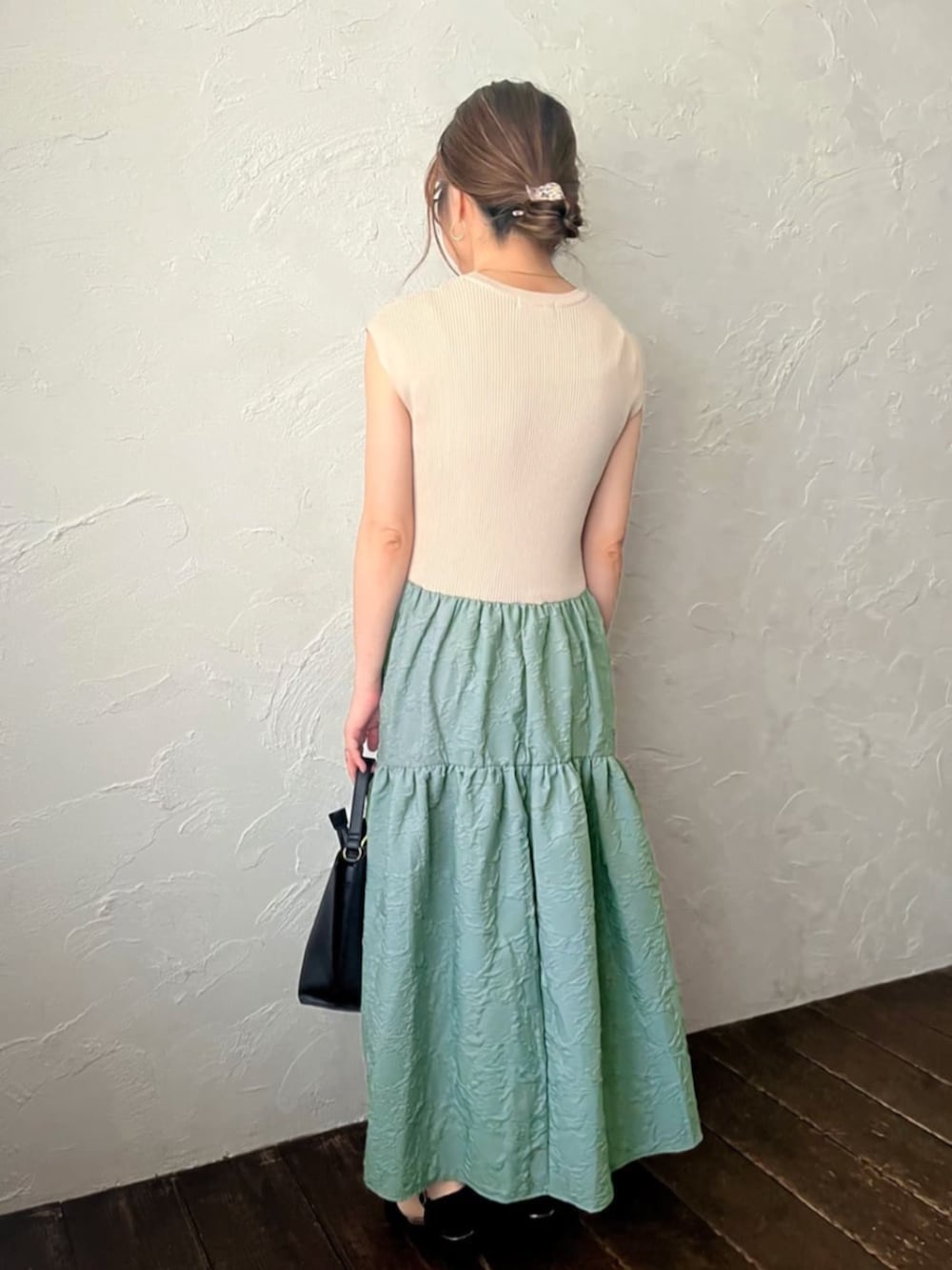 ブラック系のショルダーバッグ、グリーン系のワンピースを着用したレディースの夏コーディネートの3枚目の写真