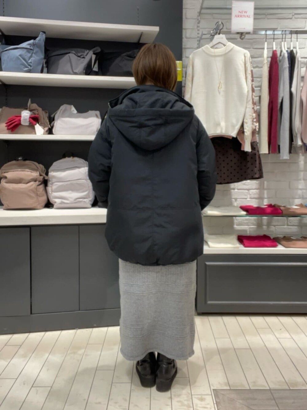 ホワイト系のTシャツ/カットソー、グレー系のスカート、ブラック系のその他アウターを着用したレディースの秋コーディネートの4枚目の写真