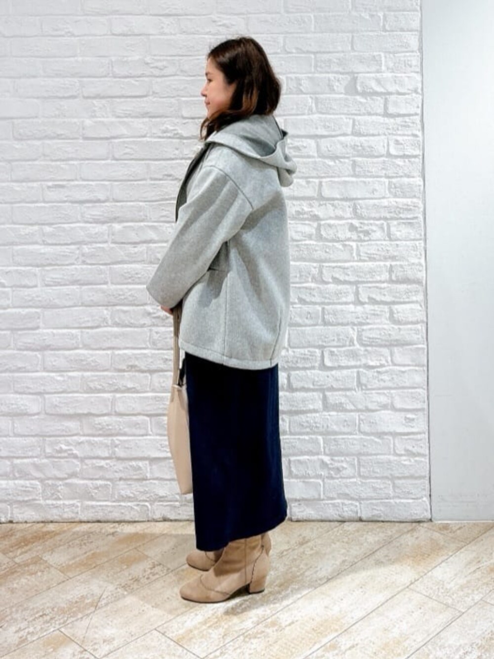 ベージュ系のブーツ、ブルー系のセットアップ、グレー系のその他アウターを着用したレディースの冬コーディネートの2枚目の写真