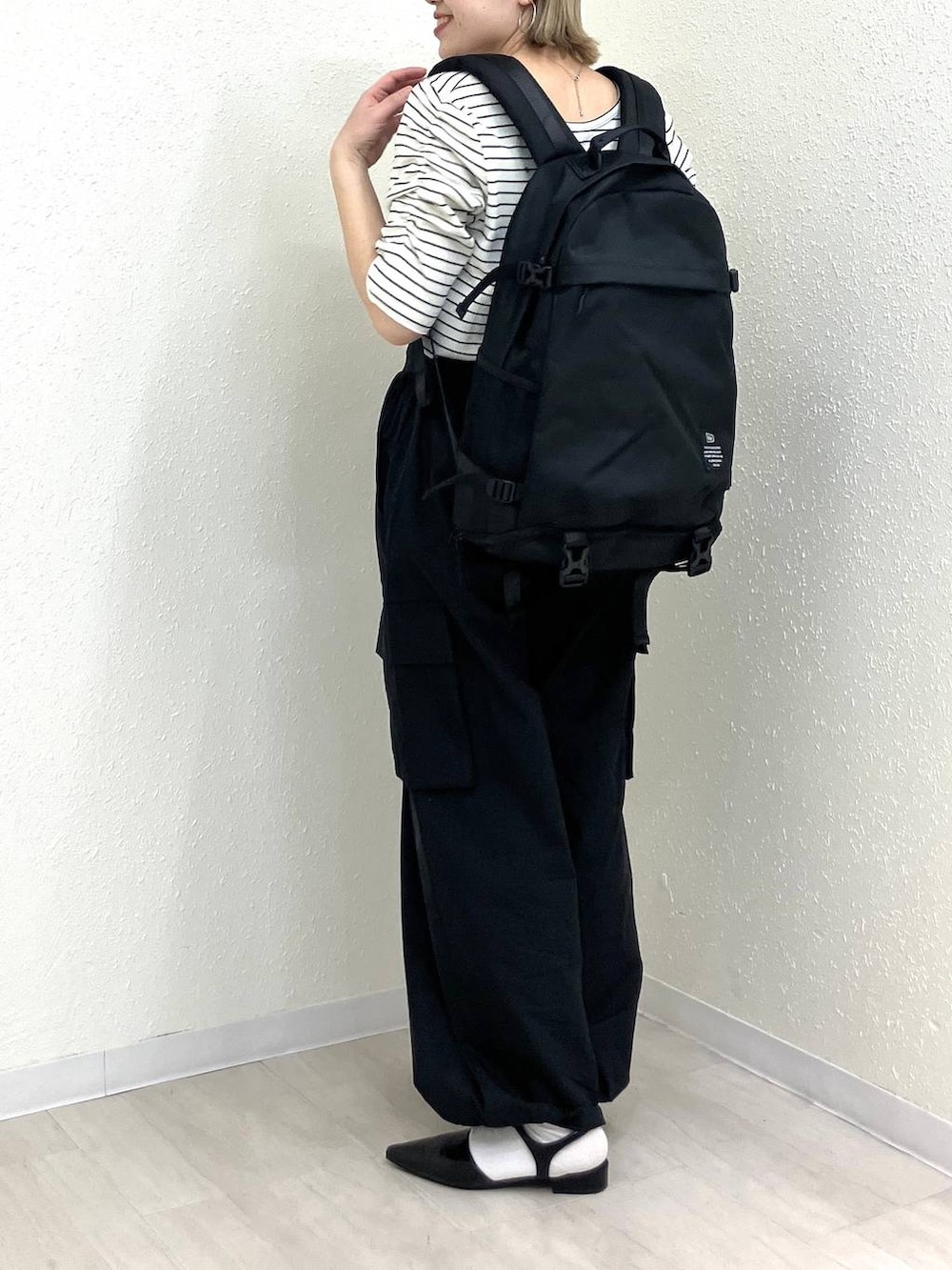ブラック系のサンダル、ブラック系のカーゴパンツ、ホワイト系のTシャツ/カットソーを着用したレディースの春コーディネートの4枚目の写真