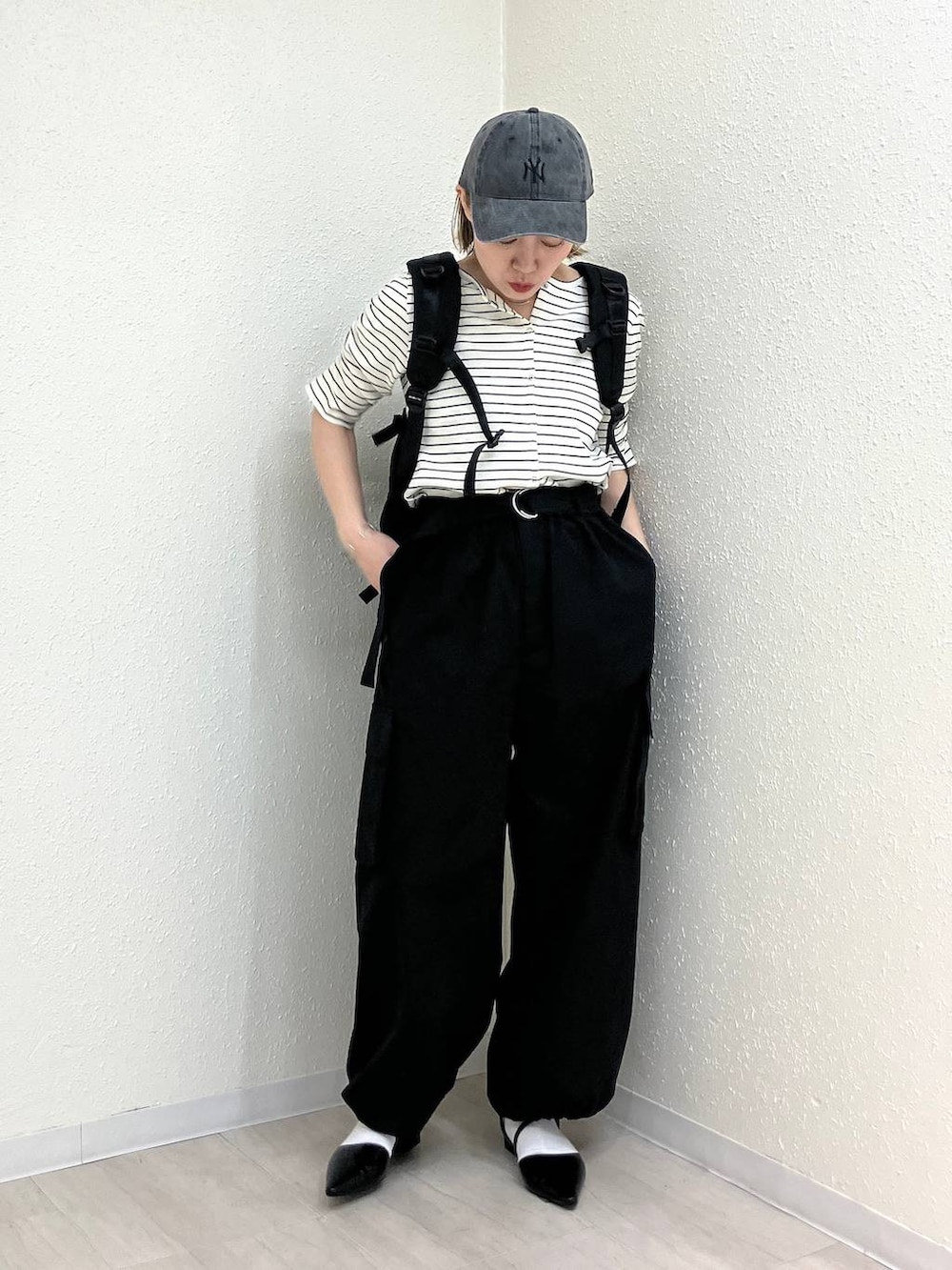 ブラック系のサンダル、ブラック系のカーゴパンツ、ホワイト系のTシャツ/カットソーを着用したレディースの春コーディネートの7枚目の写真