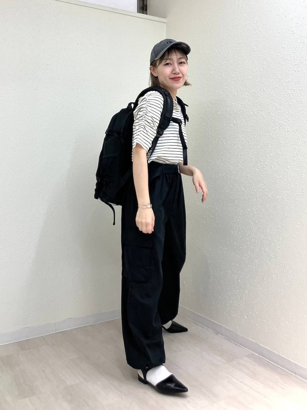 ブラック系のサンダル、ブラック系のカーゴパンツ、ホワイト系のTシャツ/カットソーを着用したレディースの春コーディネートの6枚目の写真