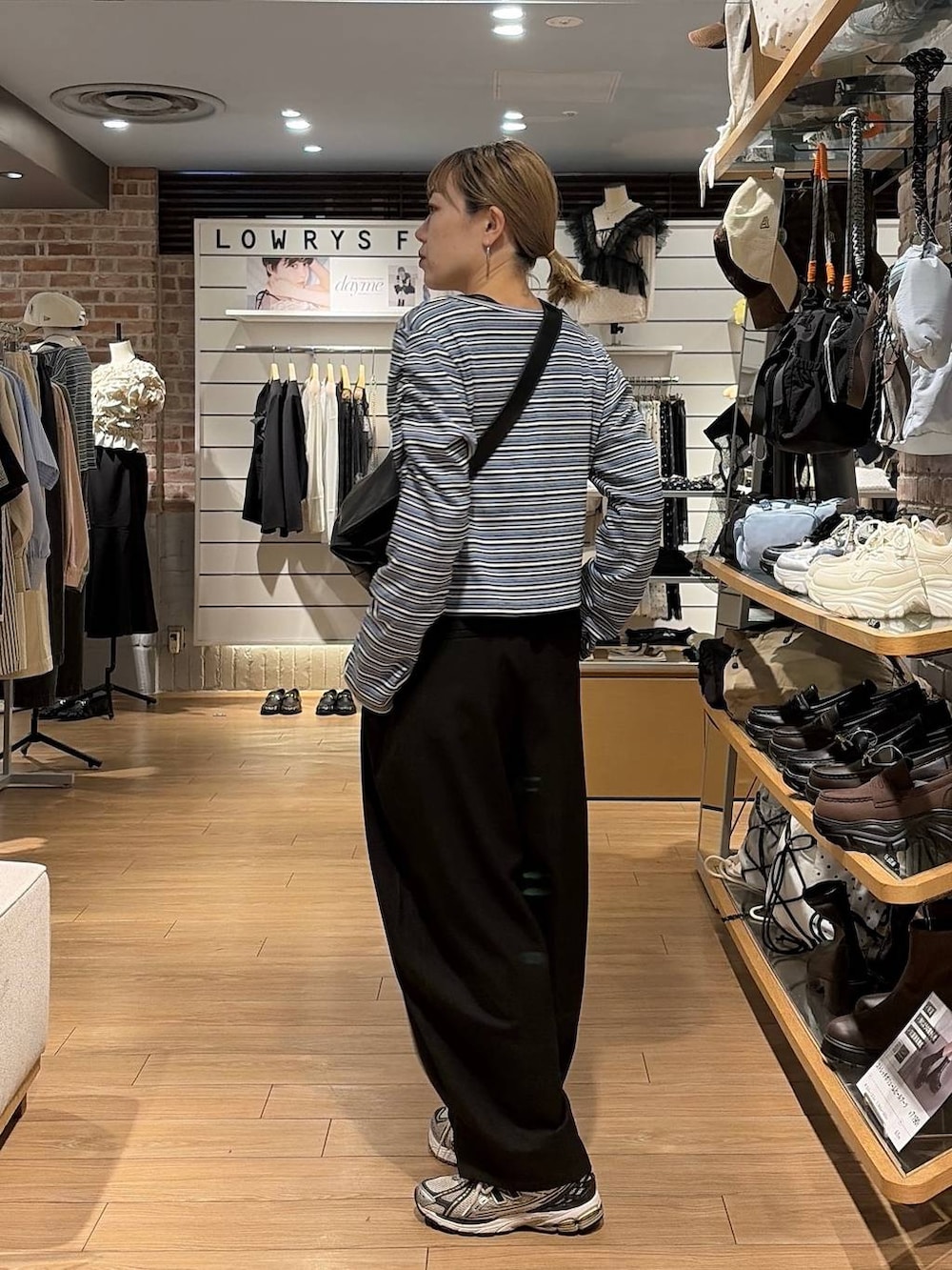 ブラック系のショルダーバッグ、ブルー系のカーディガン/ボレロ、ブラック系のその他パンツを着用したレディースの秋コーディネートの8枚目の写真