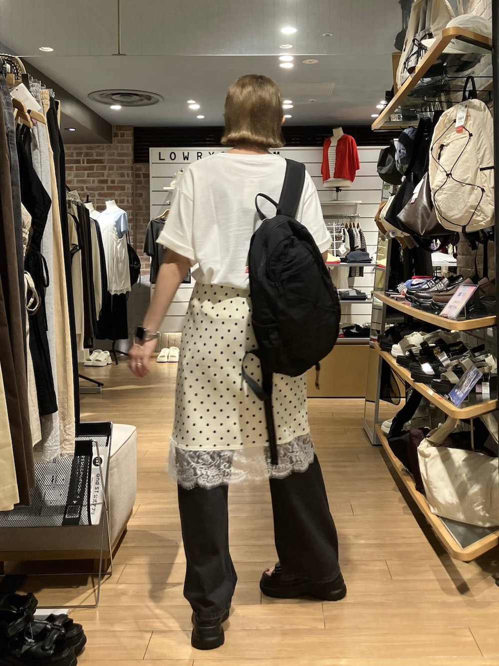ブラック系のデニムパンツ、ブラック系のバックパック/リュック、ホワイト系のスカートを着用したレディースの夏コーディネートの4枚目の写真
