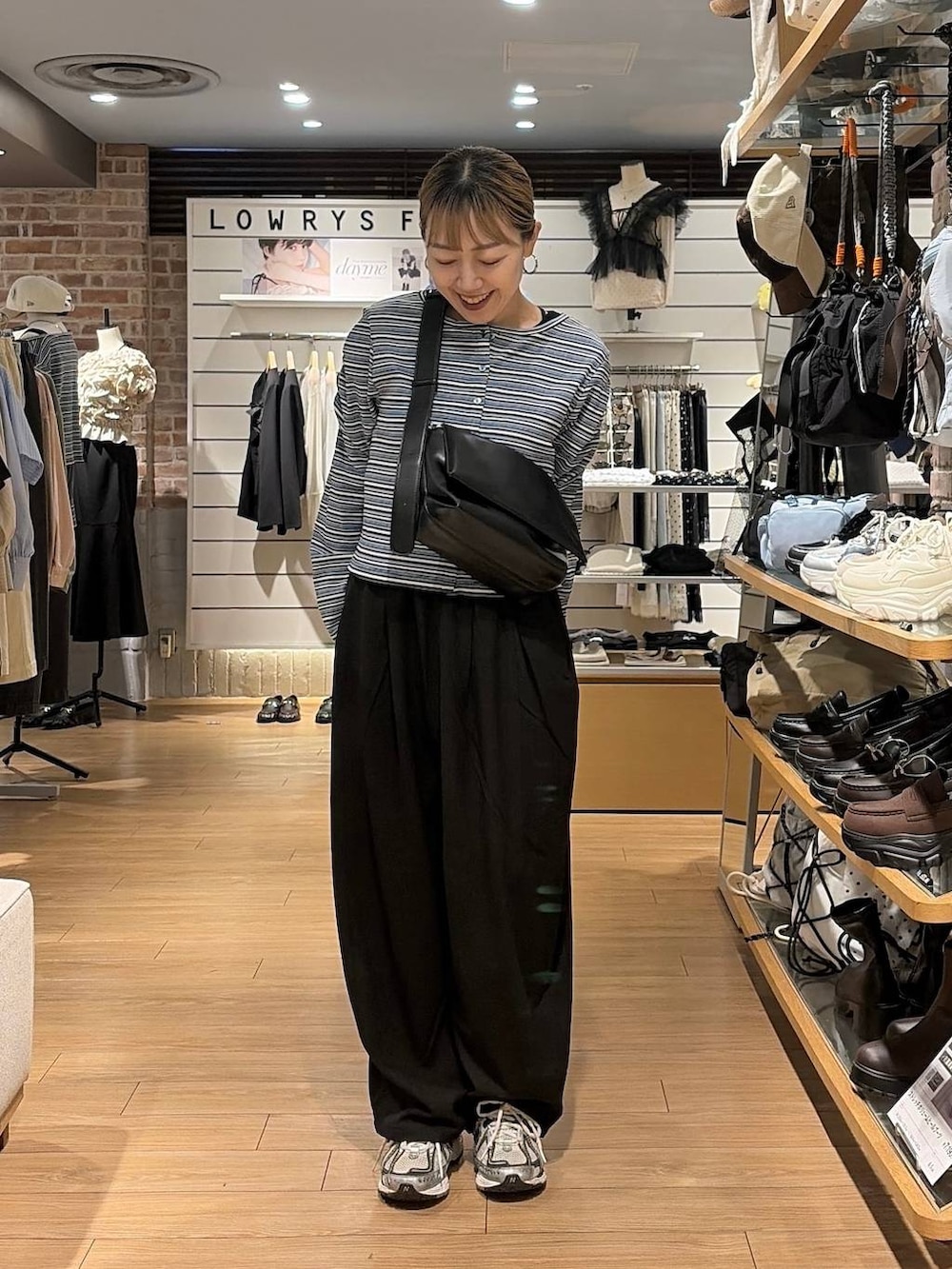 ブラック系のショルダーバッグ、ブルー系のカーディガン/ボレロ、ブラック系のその他パンツを着用したレディースの秋コーディネートの3枚目の写真